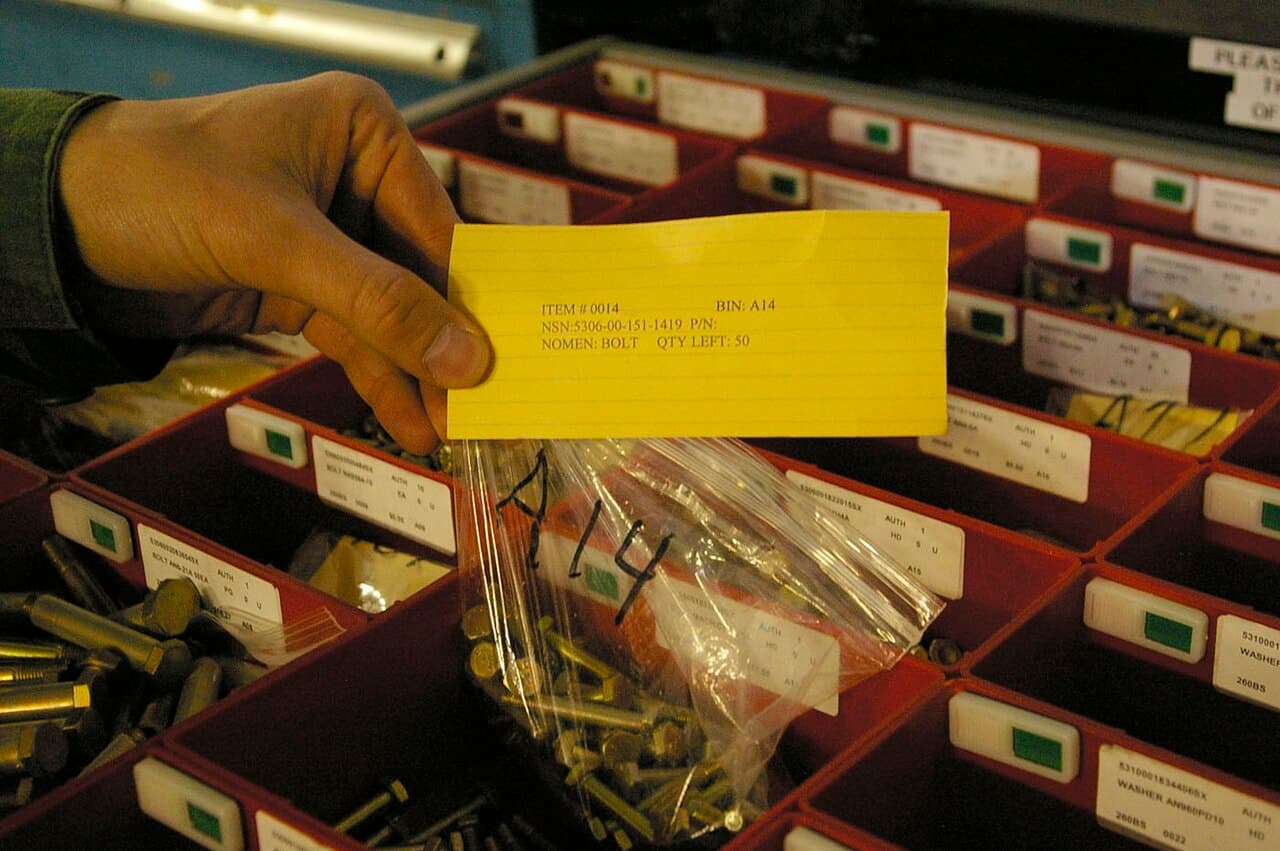 Production parts in organized bins with a physical kanban replenishment card